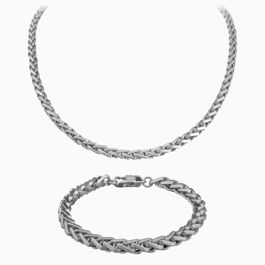 Silverfärgat wheat chain-set med halskedja och armband mot vit bakgrund – stilrent och tidlöst val.#en:color_silver,sv:farg_silver