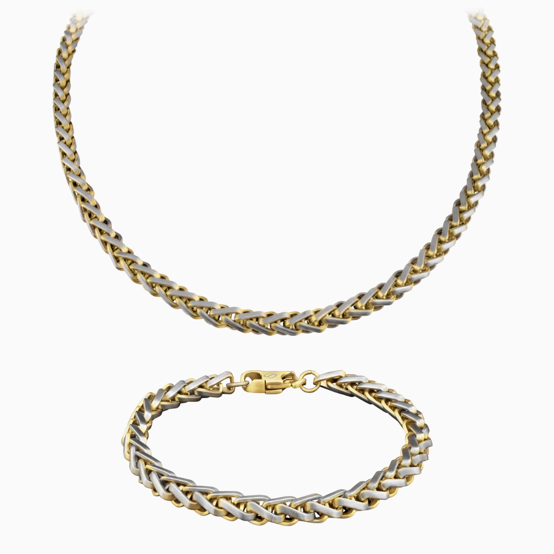 Tvåfärgat wheat chain-set med halskedja och armband i guld och silver mot vit bakgrund – stilrent och iögonfallande.#en:color_gold,sv:farg_guld