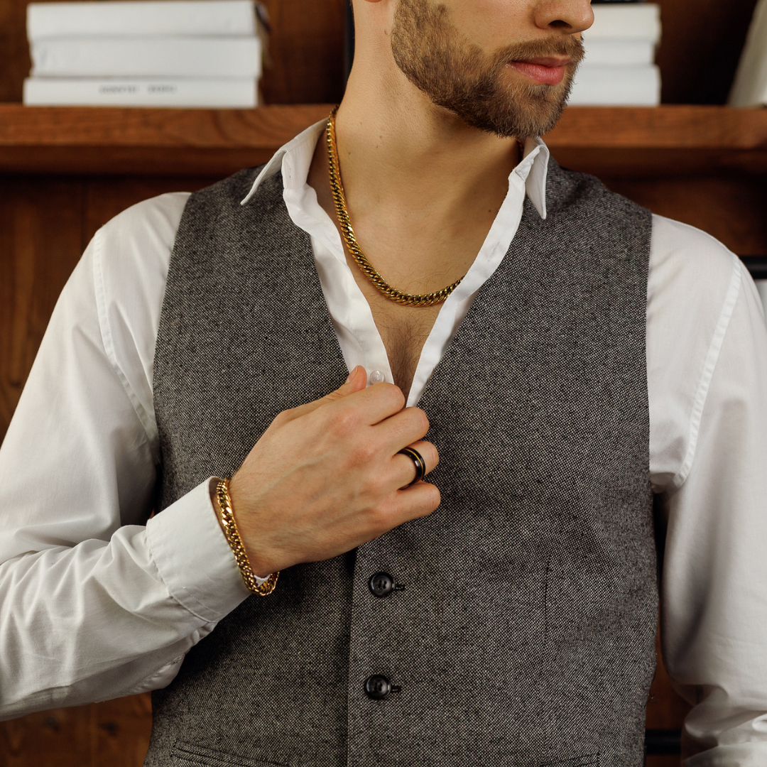 Man i vit skjorta och väst visar silverkedjan med stil i rustik miljö.#en:color_gold,sv:farg_guld