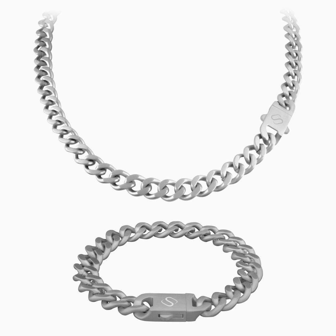 Silverfärgat cuban link-set med halskedja och armband mot vit bakgrund.#en:color_silver,sv:farg_silver