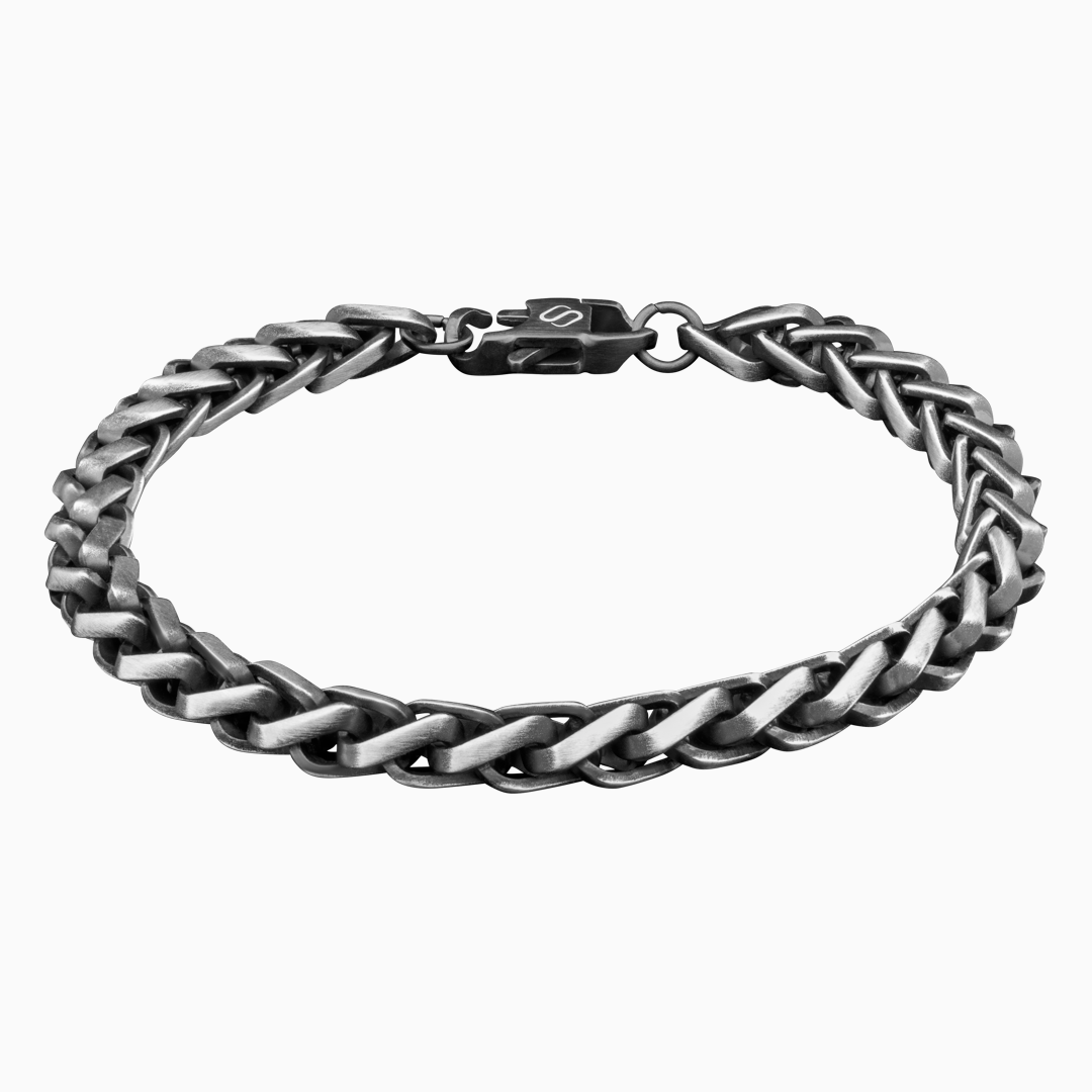 svartfärgat kedjearmband i ringform på vit bakgrund.#en:color_black,sv:farg_svart