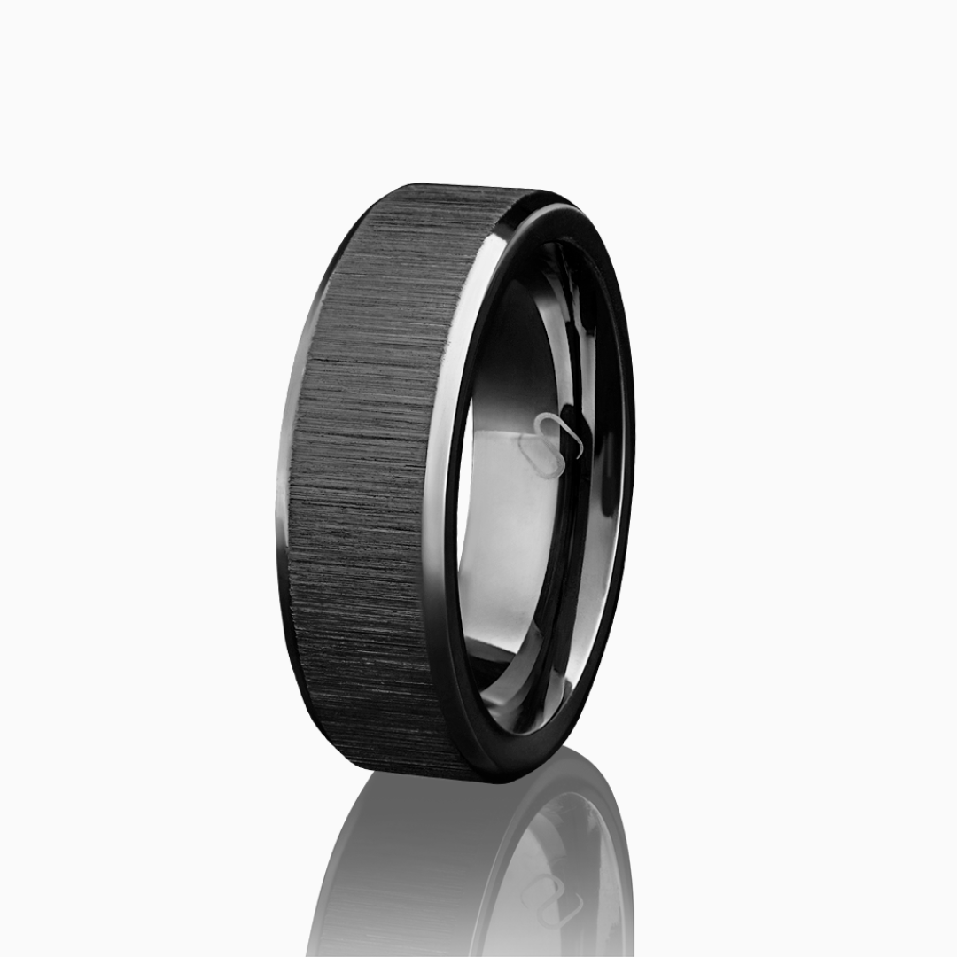 Svart ring i borstat rostfritt stål, frilagd mot vit bakgrund med reflektion.#en:color_black,sv:farg_svart