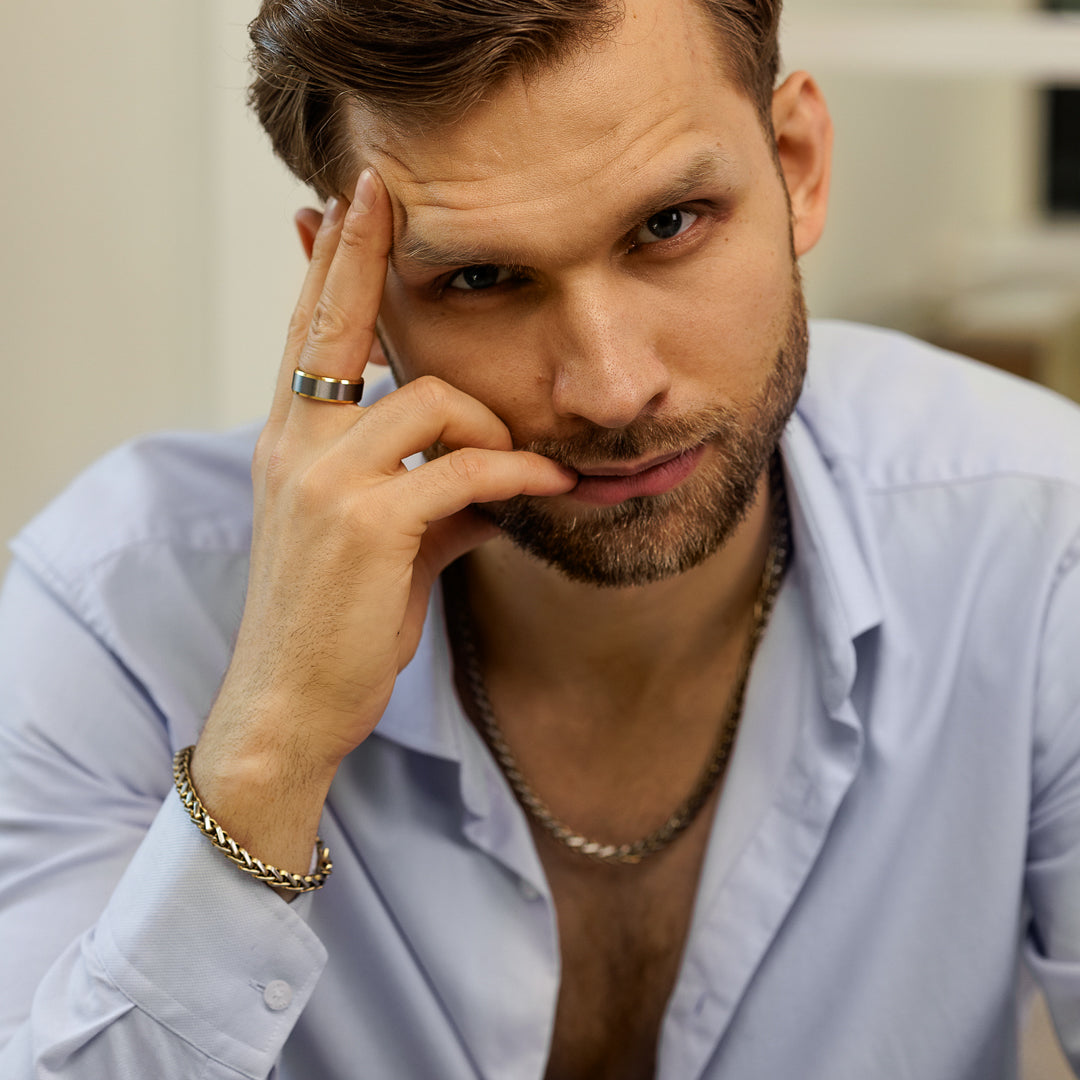 Man wearing a light blue shirt with a blurred background.
#en:color_gold,sv:farg_guld