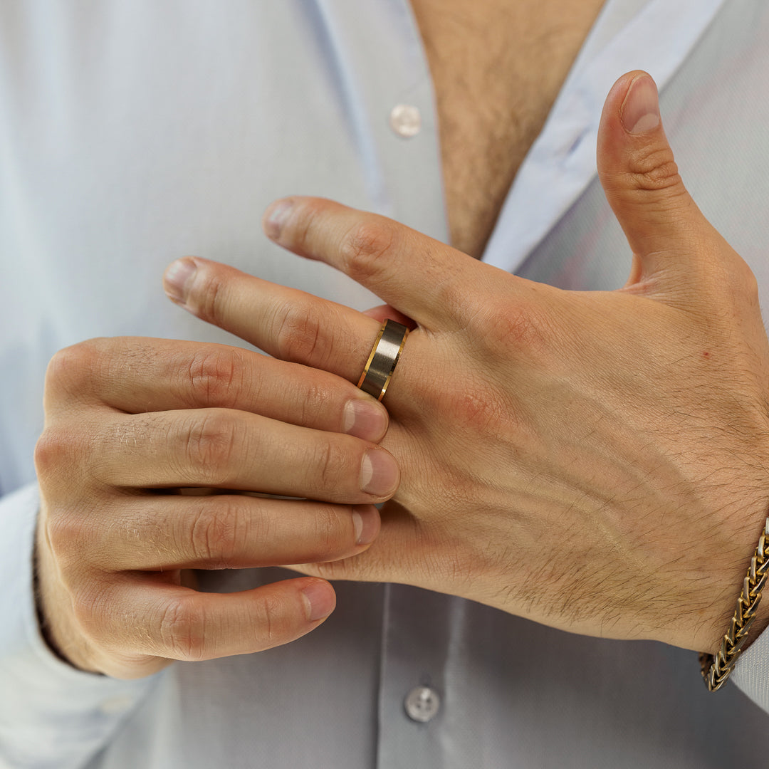 Close-up of a person's hand wearing a gold ring with a blurred background.
#en:color_silver,sv:farg_silver