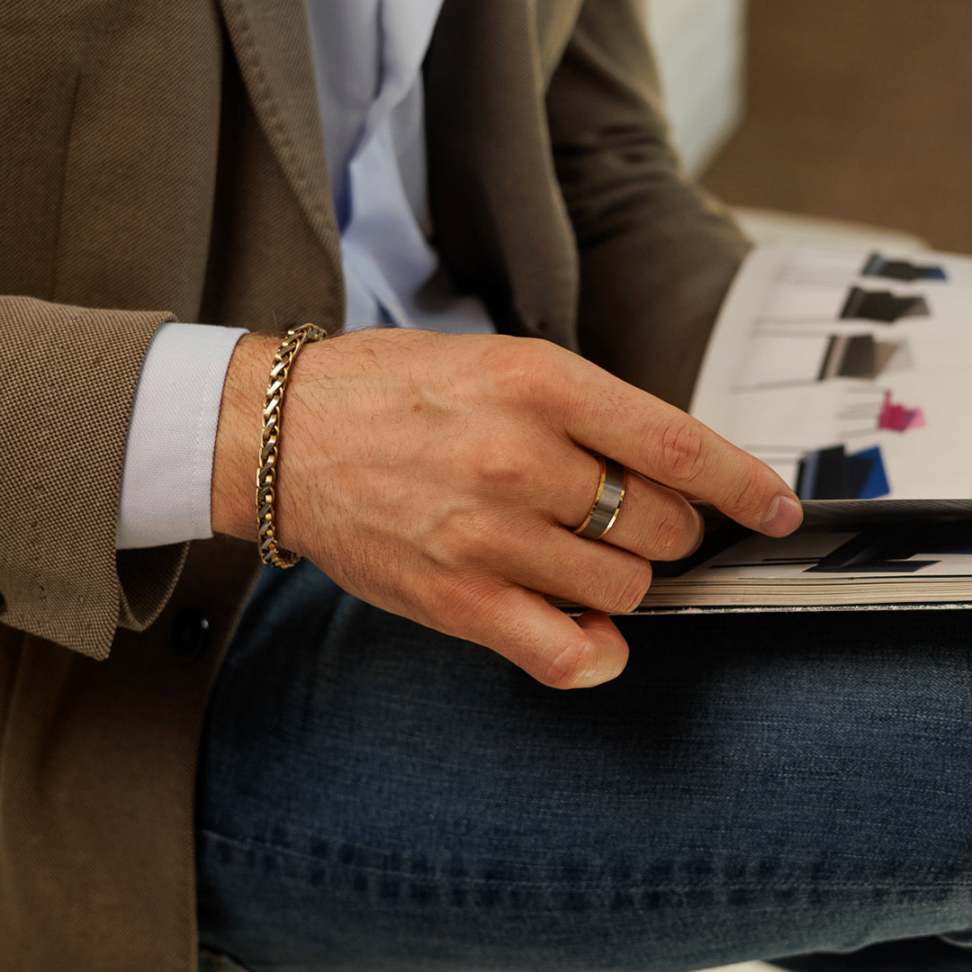 Person wearing a gold bracelet and ring, holding a photo album with a blurred background.
#en:color_silver,sv:farg_silver