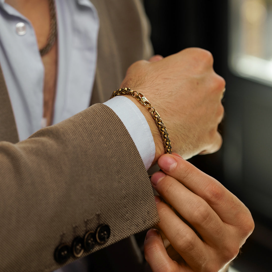 Close-up of a person adjusting the cuff of a brown suit jacket.
#en:color_gold,sv:farg_guld