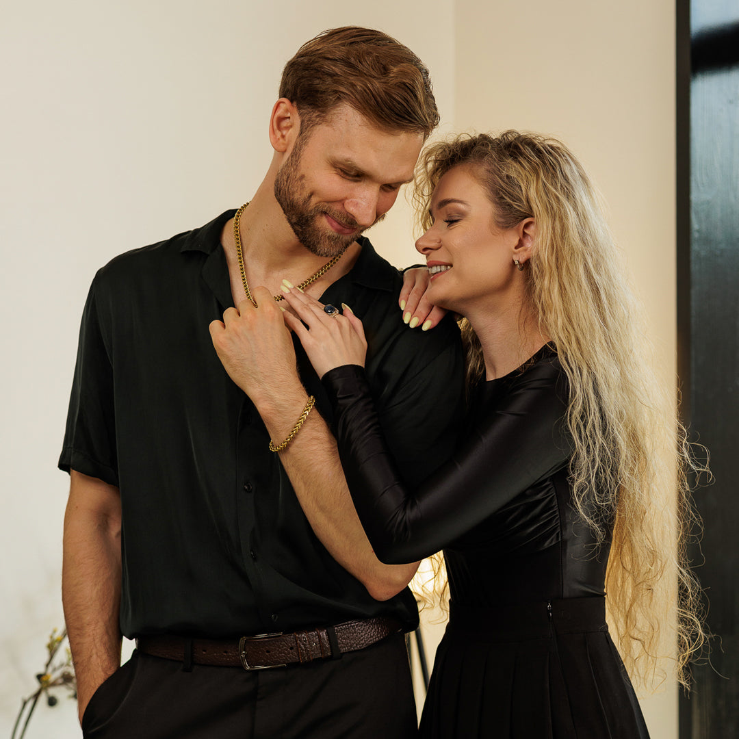 Man and woman in formal attire standing close together against a neutral background.
#en:color_gold,sv:farg_guld