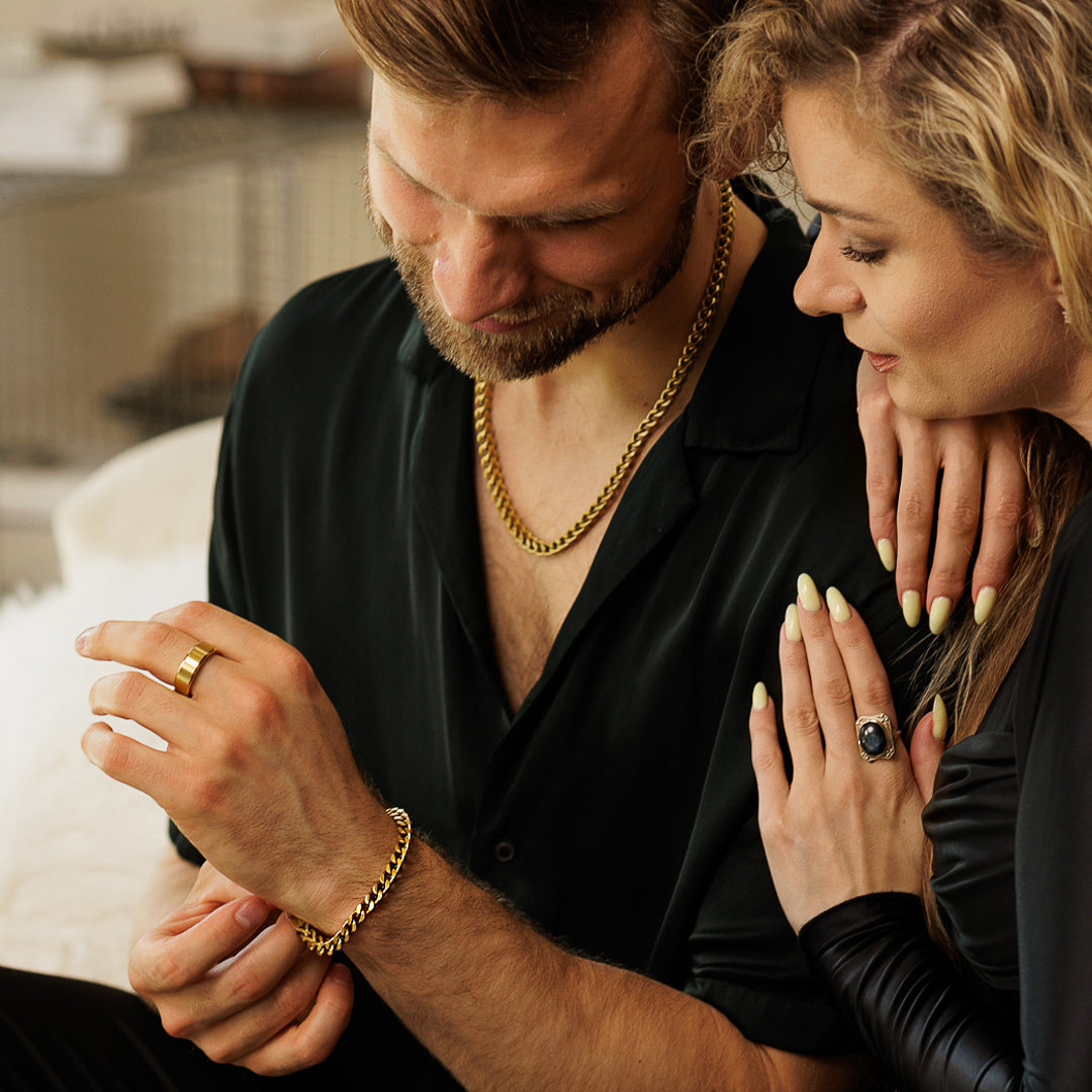 Man and woman holding hands with jewelry, close-up shot.
#en:color_gold,sv:farg_guld