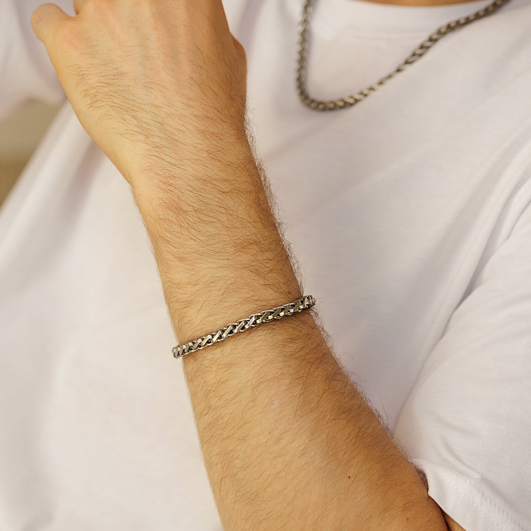 Silver bracelet on a person's wrist with a neutral background.
#en:color_silver,sv:farg_silver