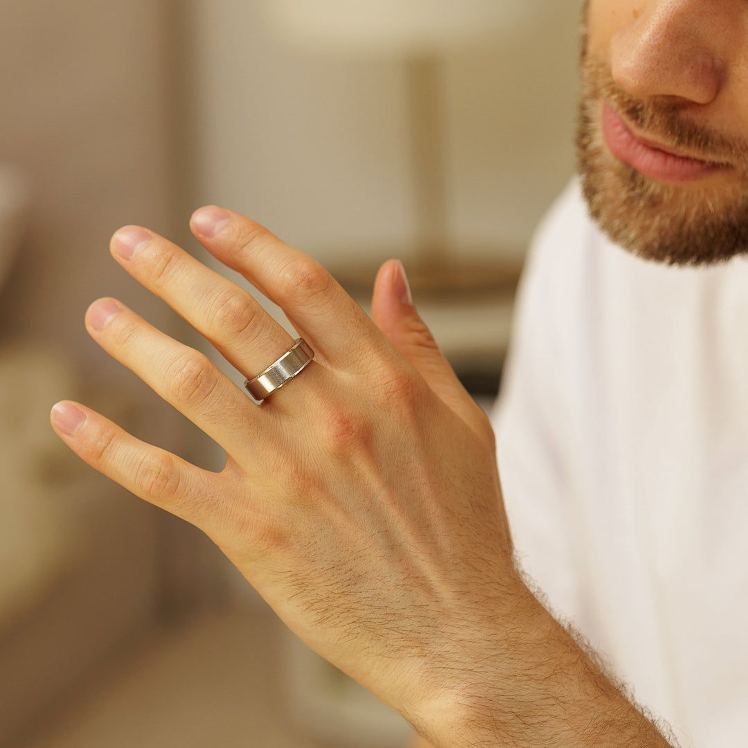 Hand wearing a silver ring with a blurred background.
#en:color_silver,sv:farg_silver