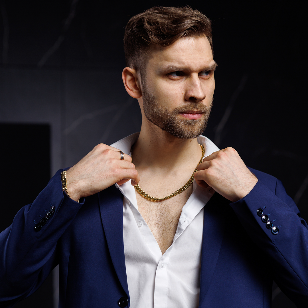 Man i blå kavaj bär kedjan för en modern och maskulin look.#en:color_gold,sv:farg_guld