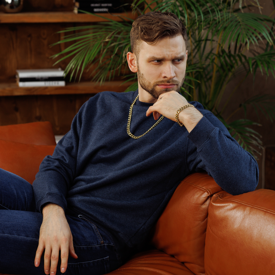 Stilren man i soffan, bär setet med självsäker elegans i varm miljö.#en:color_gold,sv:farg_guld