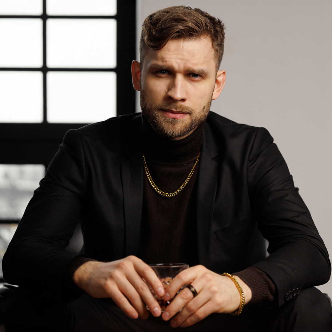 Guldiga länkar i fokus när han poserar vid fönster – sofistikerat och kraftfullt.#en:color_gold,sv:farg_guld