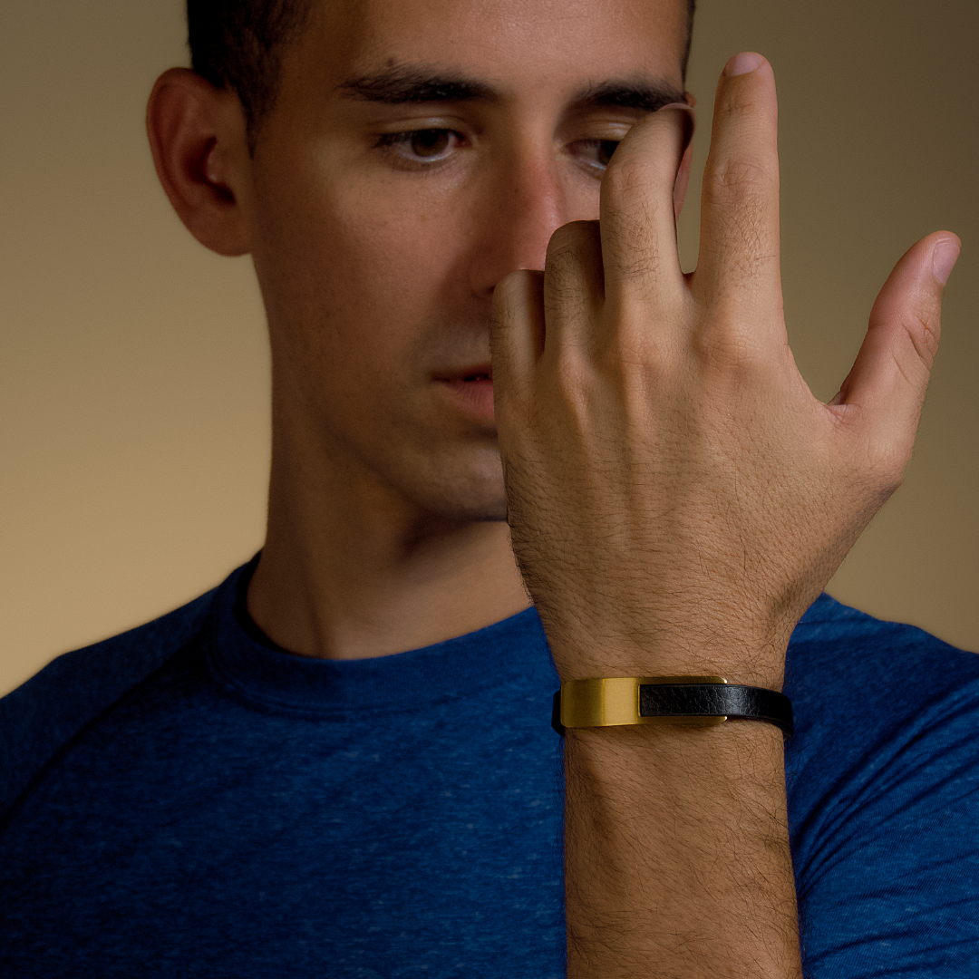 Guldig detalj blänker på handleden när man täcker ansiktet – stilren och kreativ vinkel.
#en:color_gold,sv:farg_guld