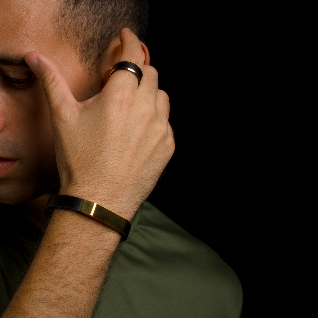 Stilren närbild när man rättar till håret, gulddetaljen blänker mot svart bakgrund.
#en:color_gold,sv:farg_guld