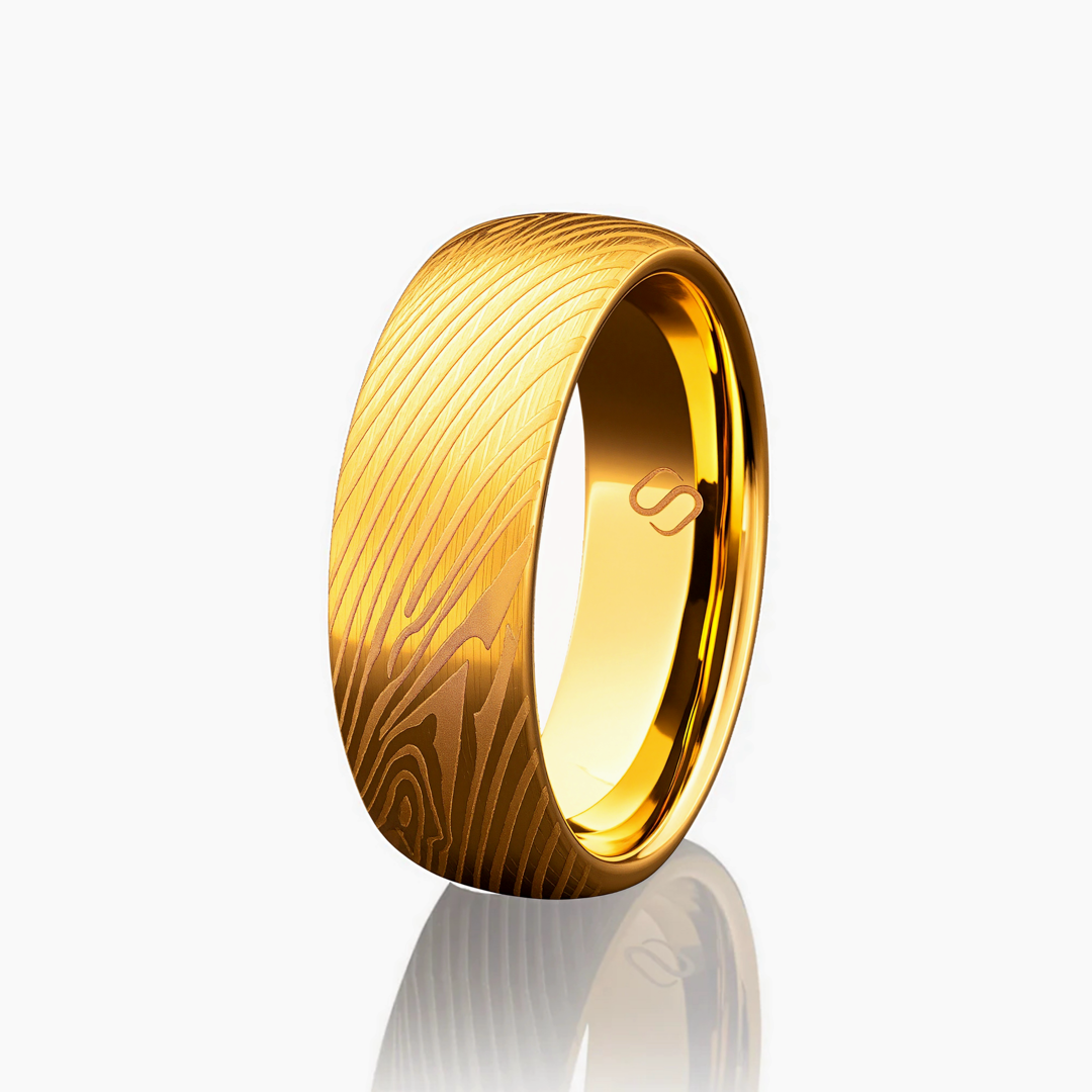 Guldfärgad tungstenring med trästruktur, stilrent fotograferad mot vit bakgrund.#en:color_gold,sv:farg_guld