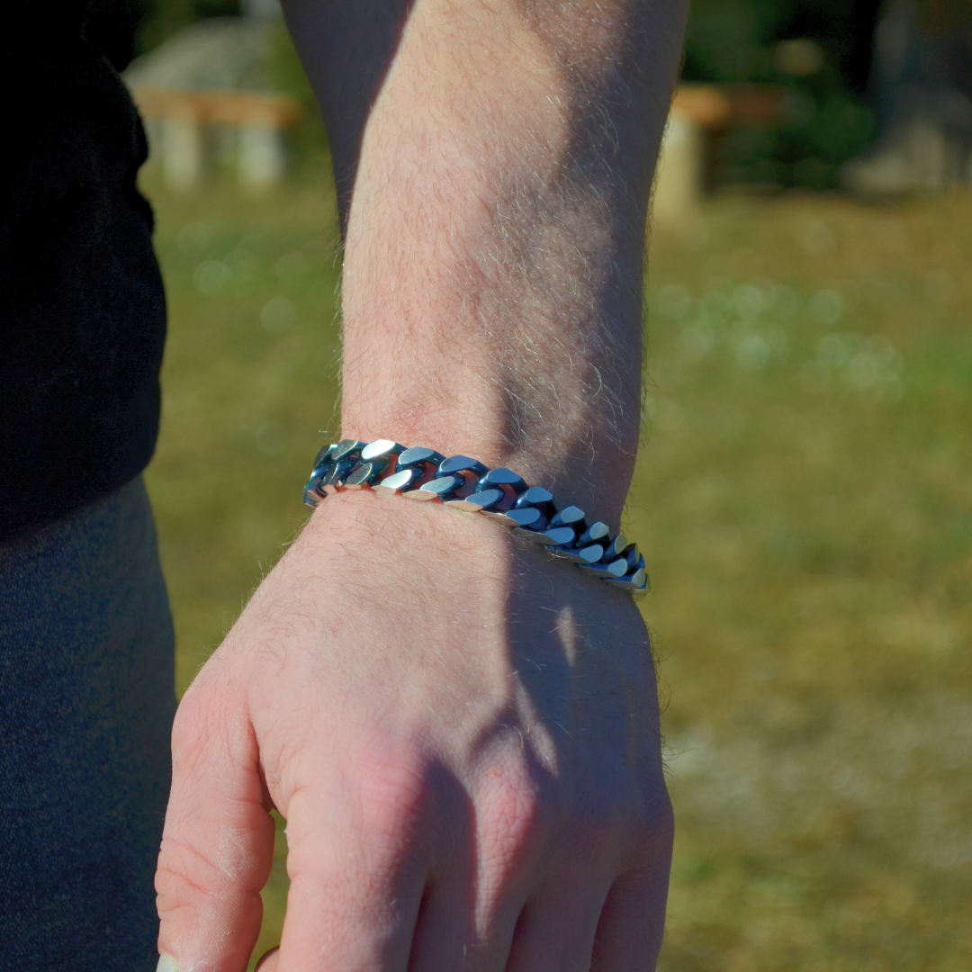 Armbandet syns på handled i dagsljus, utomhusmiljö med naturligt ljus.#en:color_blue,sv:farg_bla