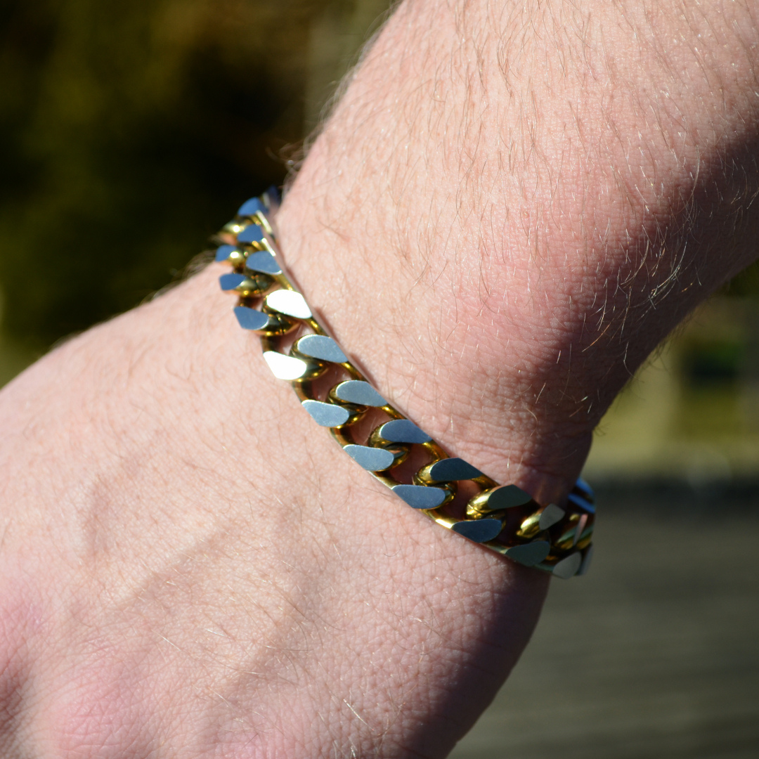 Närbild på guldfärgat armband i kubansk stil, länkarna fångar ljuset snyggt.#en:color_gold,sv:farg_guld