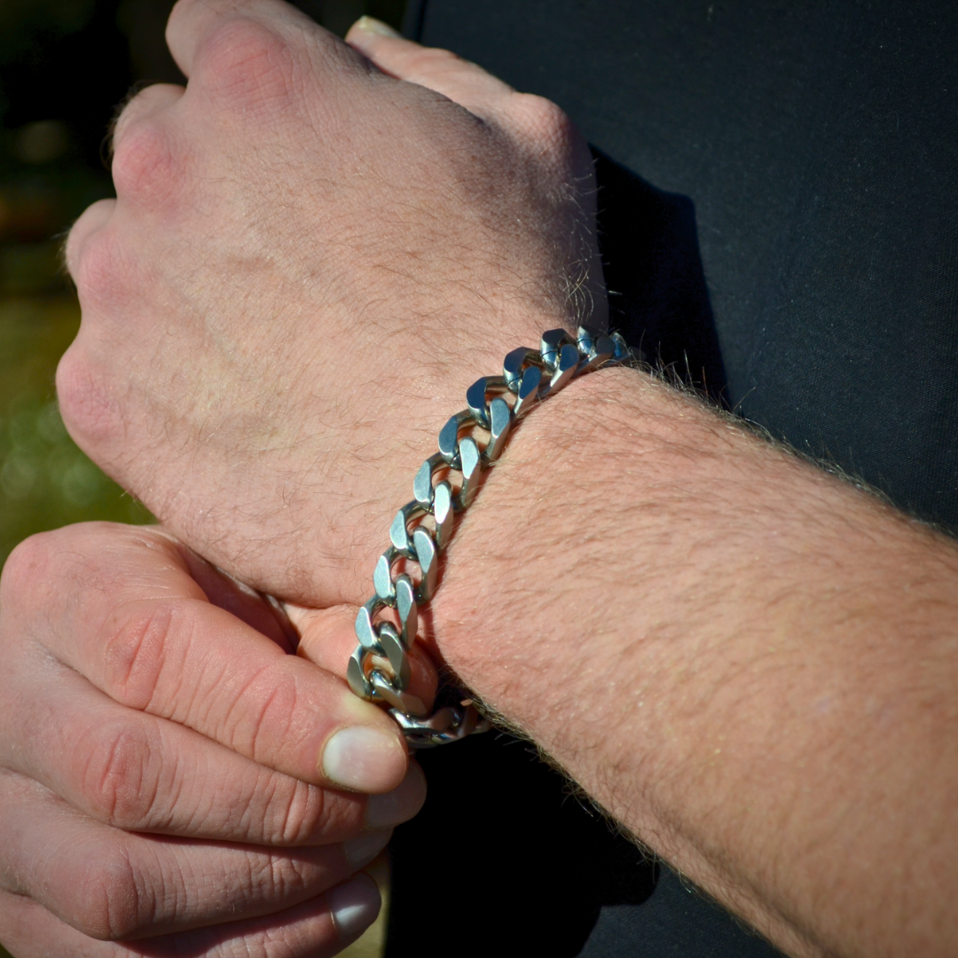 Handled i rörelse, silverarmbandet lyser mot huden i naturligt ljus.#en:color_silver,sv:farg_silver