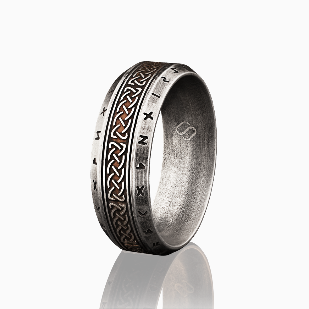 Silverfärgad stålringen med keltiskt knutmönster och runor, frilagd med spegling mot vit bakgrund.