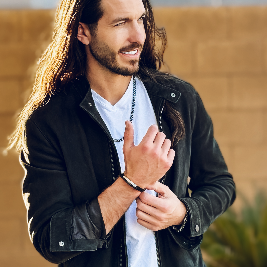 Leende man i ljusfärgad t-shirt med jacka bär armbandet#en:color_silver,sv:farg_silver