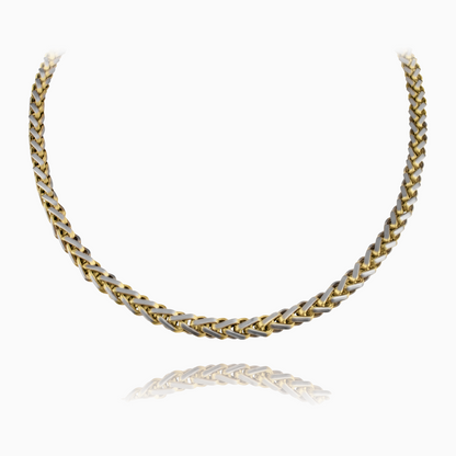 Guld wheat chain-halskedja med glänsande flätad struktur, frilagd mot vit bakgrund.
