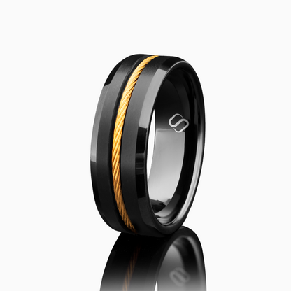 Svart tungstenring med glänsande gulddetalj i mitten, frilagd mot vit bakgrund.