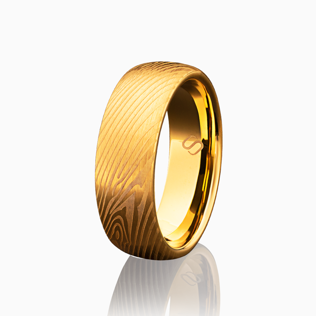 Guldfärgad tungstenring med trästruktur, stilrent fotograferad mot vit bakgrund.#en:color_gold,sv:farg_guld
