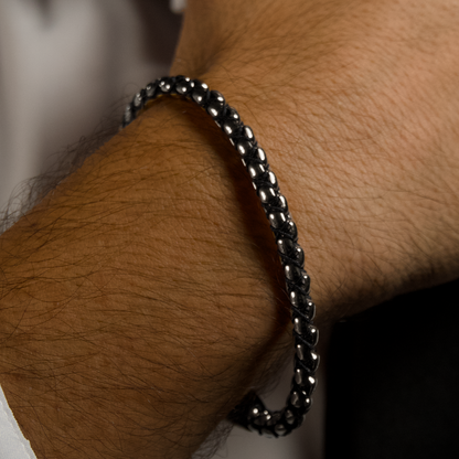 Närbild på manlig handled, armbandet adderar karaktär till den dressade looken.