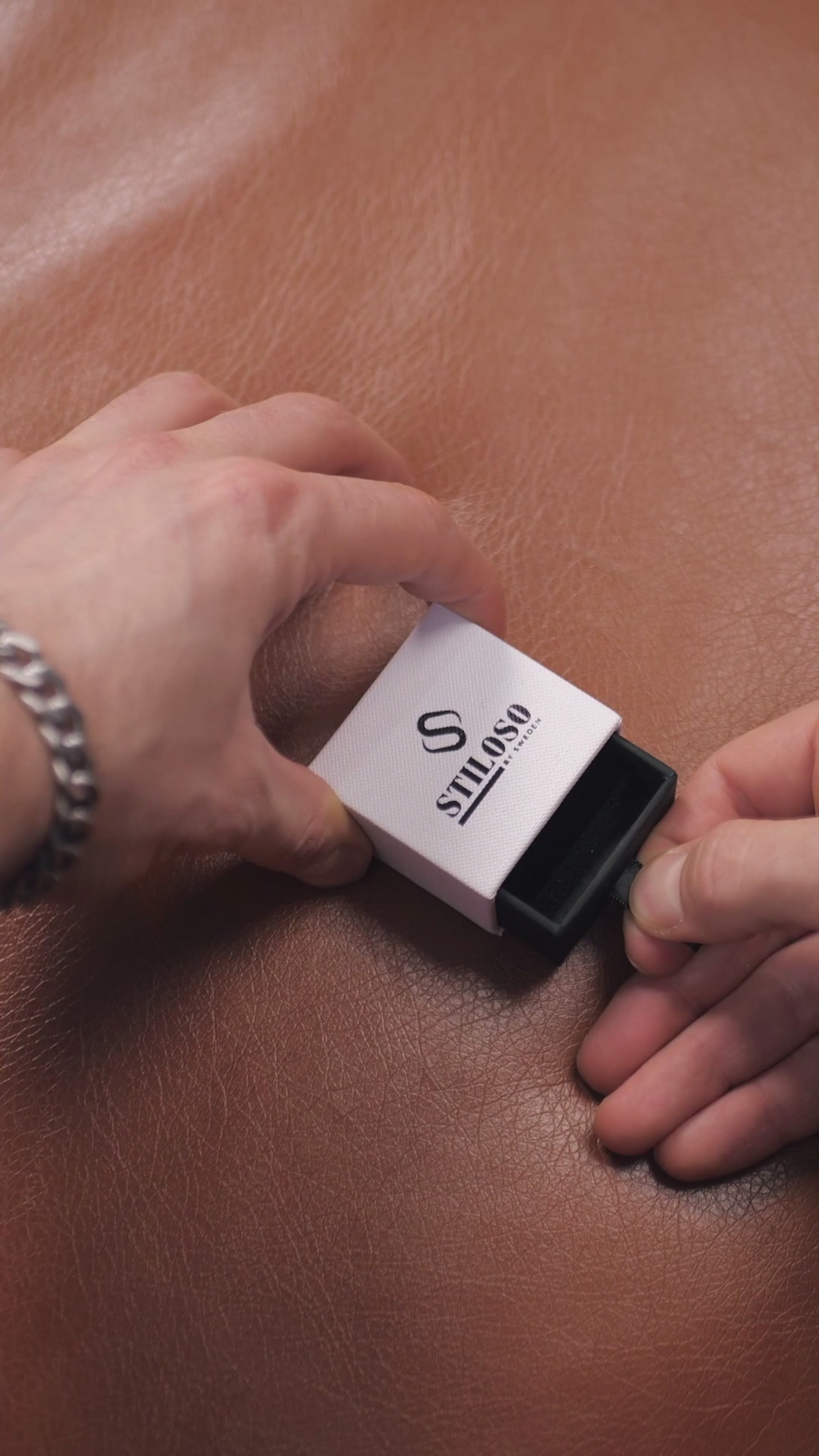 Videoikon över man som bär tvåfärgad tungstenring, elegant miljö och självsäker utstrålning.