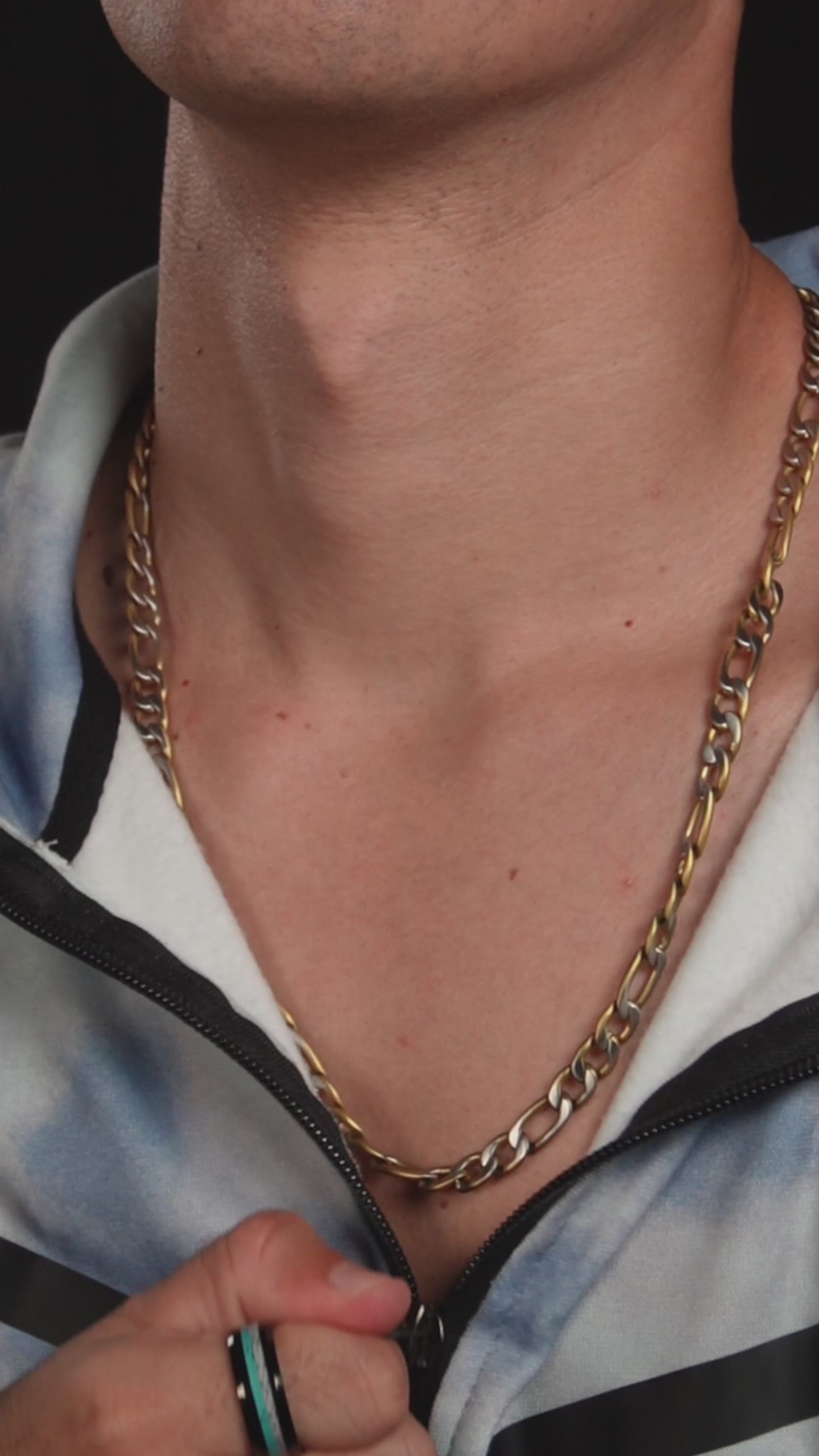 Man bär Arctic Glimmer-ringen nära halsen som bär figaro halsband.